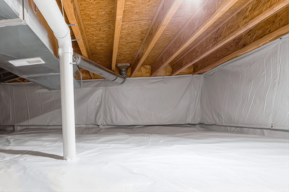 Crawl space under house with white moisture barrier on floor, exposed wooden joists and beams, and central support column.
